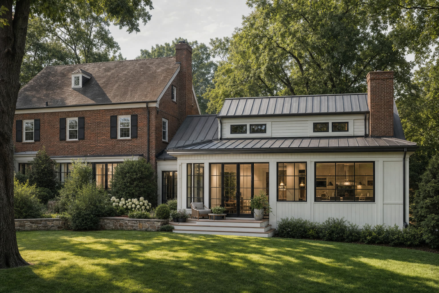 Rear addition on a brick colonial home with standing seam metal roof and black-framed windows.